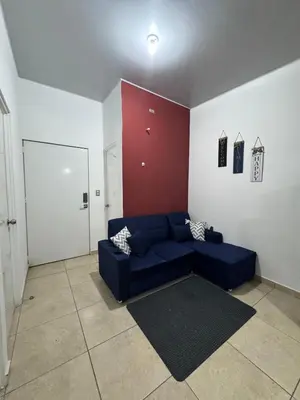 a living room with a blue couch and a red wall at La Santanita in Santa Ana