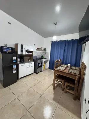 a kitchen with a table and a stove and a refrigerator at La Santanita in Santa Ana