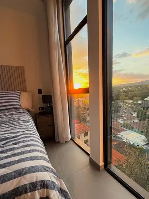 a bedroom with a bed and a large window at Cozy apartment in San Benito in San Salvador