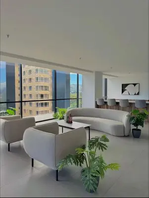 a living room with couches and tables in a building at Cozy apartment in San Benito in San Salvador