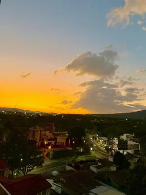 a view of a city with a sunset in the background at Cozy apartment in San Benito in San Salvador