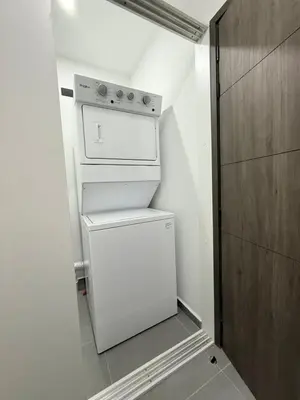 a small white refrigerator in a small kitchen at Cozy apartment in San Benito in San Salvador