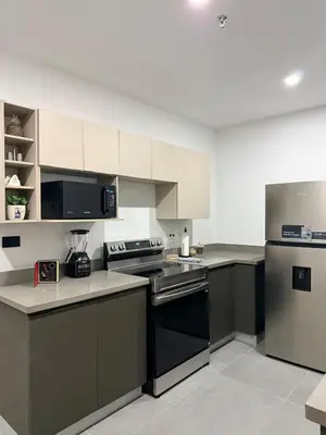a kitchen with black appliances and white cabinets at Cozy apartment in San Benito in San Salvador