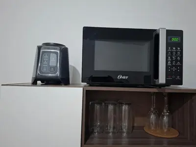 a microwave and a cell phone and glasses on a shelf at Nueva San Miguel - Casa Chaparrastique in San Miguel