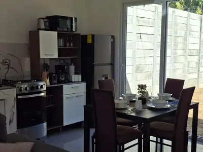 a kitchen with a table with chairs and a refrigerator at Nueva San Miguel - Casa Chaparrastique in San Miguel