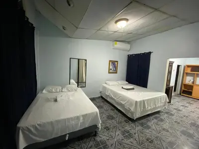 a room with two beds in a room at Hostal Morales García in San Marcos
