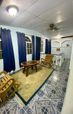 a room with blue curtains and a table and chairs at Hostal Morales García in San Marcos