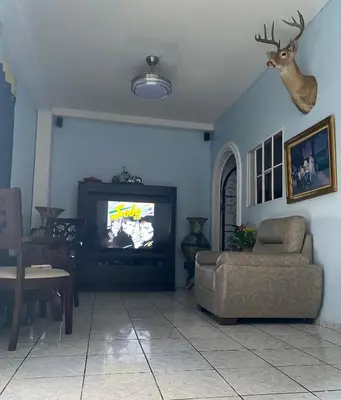 a living room with a tv and a chair at Hostal Morales García in San Marcos