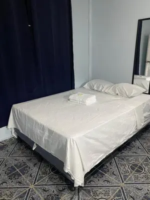 a bed with white sheets and pillows on it at Hostal Morales García in San Marcos