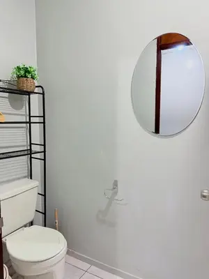 a bathroom with a toilet and a mirror on the wall at Casa Armon - Frente a Estadio Cuscatlán in San Salvador