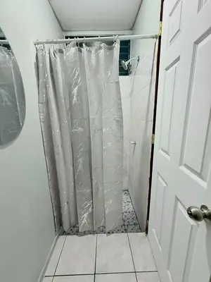 a shower with a shower curtain in a bathroom at Casa Armon - Frente a Estadio Cuscatlán in San Salvador