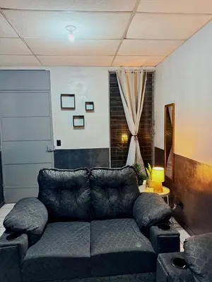 a living room with a couch and a window at Casa Armon - Frente a Estadio Cuscatlán in San Salvador