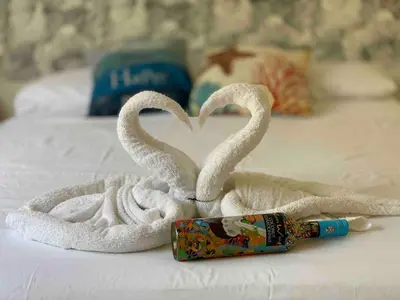two swans made out of towels on a bed at Makai Beach Apartment in El Zapote