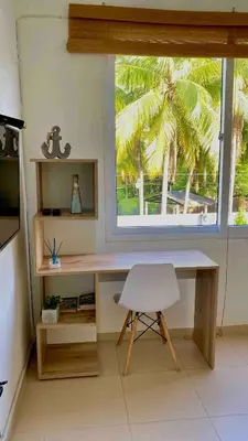a desk and a chair in a room with a window at Makai Beach Apartment in El Zapote