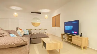 a living room with a couch and a flat screen tv at Makai Beach Apartment in El Zapote