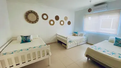 a room with two twin beds and a window at Makai Beach Apartment in El Zapote