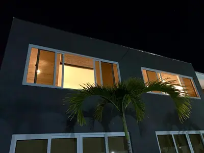 a blue house with a palm tree in front of it at Makai Beach Apartment in El Zapote