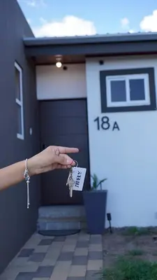 a hand holding a pair of keys in front of a house at New, Peaceful Bonavista Home! in Zaragoza