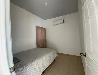 a small bedroom with a bed and a window at Casa acogedora con piscina y seguridad las 24 horas in Ahuachapán
