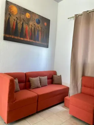 a living room with a red couch and a painting at Casa acogedora con piscina y seguridad las 24 horas in Ahuachapán