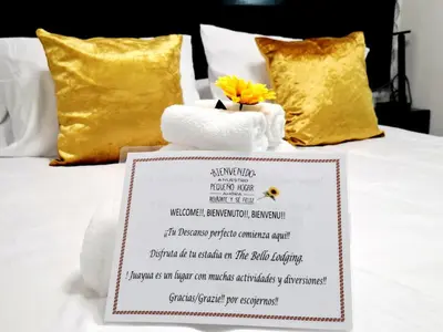 a hotel room menu on a bed with a towel at The Bello Lodging in Sonsonate