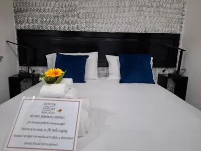 a bedroom with a large bed with a sign on it at The Bello Lodging in Sonsonate