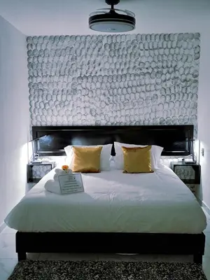 a bedroom with a large bed with a large headboard at The Bello Lodging in Sonsonate
