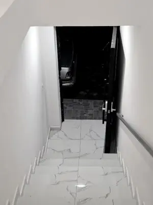 a stairway leading up to a hallway with white marble floors at The Bello Lodging in Sonsonate