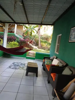 a room with a hammock and a green wall at Casa de playa en lomas de san blas in Playa San Blas