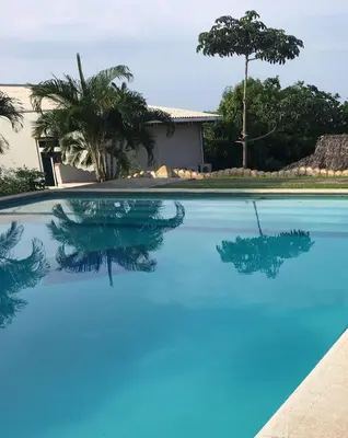a swimming pool with blue water in front of a house at Casa de playa en lomas de san blas in Playa San Blas