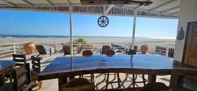 a table in a room with a view of the beach at Beachfront House The Hope in San Luis