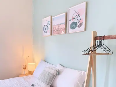 a bedroom with three pictures hanging above a bed at Cozy Loft with pool and beach in Surf City in La Libertad