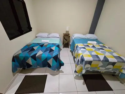 two beds sitting next to each other in a room at The Stone Way Suite in Juayúa