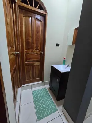 a bathroom with a wooden door and a sink at The Stone Way Suite in Juayúa