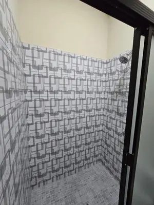 a bathroom with a shower with a tiled wall at The Stone Way Suite in Juayúa