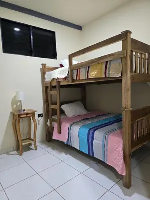 a bedroom with two bunk beds and a table at The Stone Way Suite in Juayúa