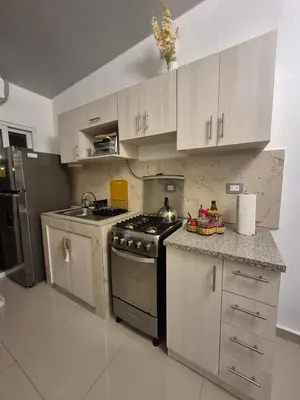 a kitchen with white cabinets and a stove top oven at Casa Mia en San Miguel