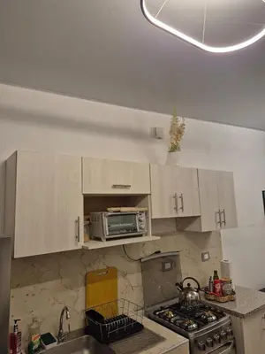 a kitchen with white cabinets and a sink and a microwave at Casa Mia en San Miguel