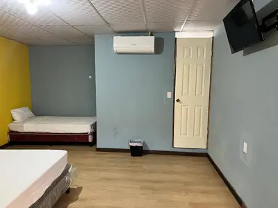 a room with two beds and a white door at Hostal Noche de Luna in San Salvador