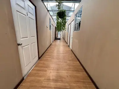 an empty hallway with a white door and a wooden floor at Hostal Noche de Luna in San Salvador