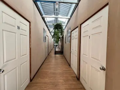 a hallway with white doors and a glass ceiling at Hostal Noche de Luna in San Salvador