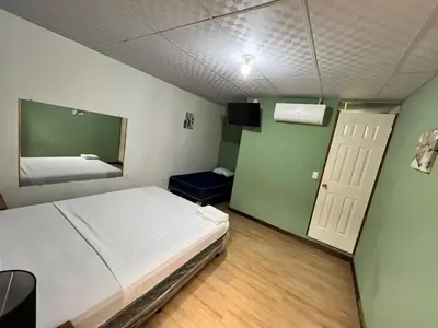a small room with a bed and a mirror at Hostal Noche de Luna in San Salvador