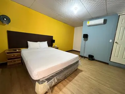 a bedroom with a large bed in a yellow room at Hostal Noche de Luna in San Salvador