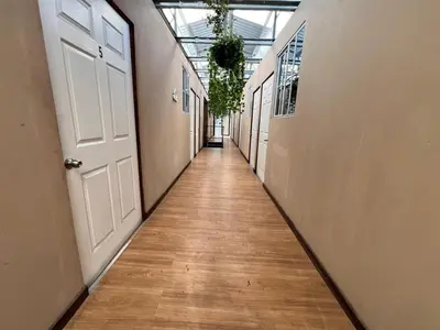 an empty hallway with a white door and a wooden floor at Hostal Noche de Luna in San Salvador