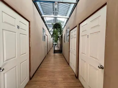 a hallway with white doors and a glass ceiling at Hostal Noche de Luna in San Salvador