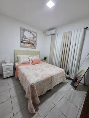 a bedroom with a bed with a blanket and curtains at Casa Luna Villa Verde State in Santa Ana