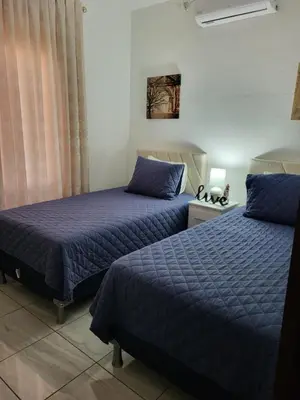 two beds sitting next to each other in a bedroom at Casa Luna Villa Verde State in Santa Ana