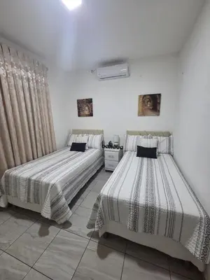 two beds in a room with white walls at Casa Luna Villa Verde State in Santa Ana