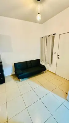 a living room with a black couch in a room at Casa de Sasha