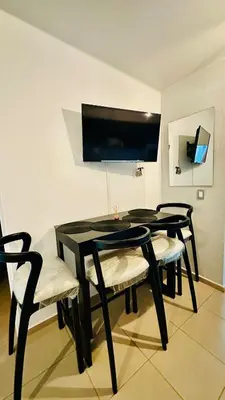 a black dining room table with four chairs and a tv at Casa de Sasha